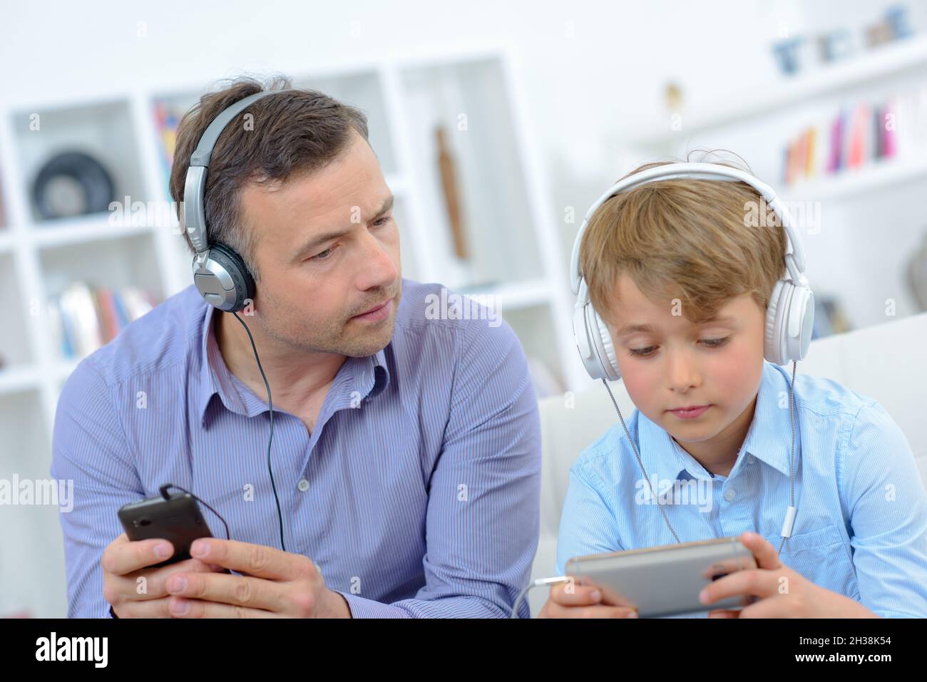 il ragazzino sta usando il suo telefono dads Foto Stock