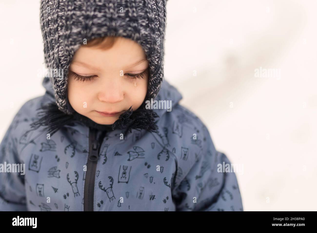 Toddler in inverno oneseie e cappello di lana con lacrima Foto Stock