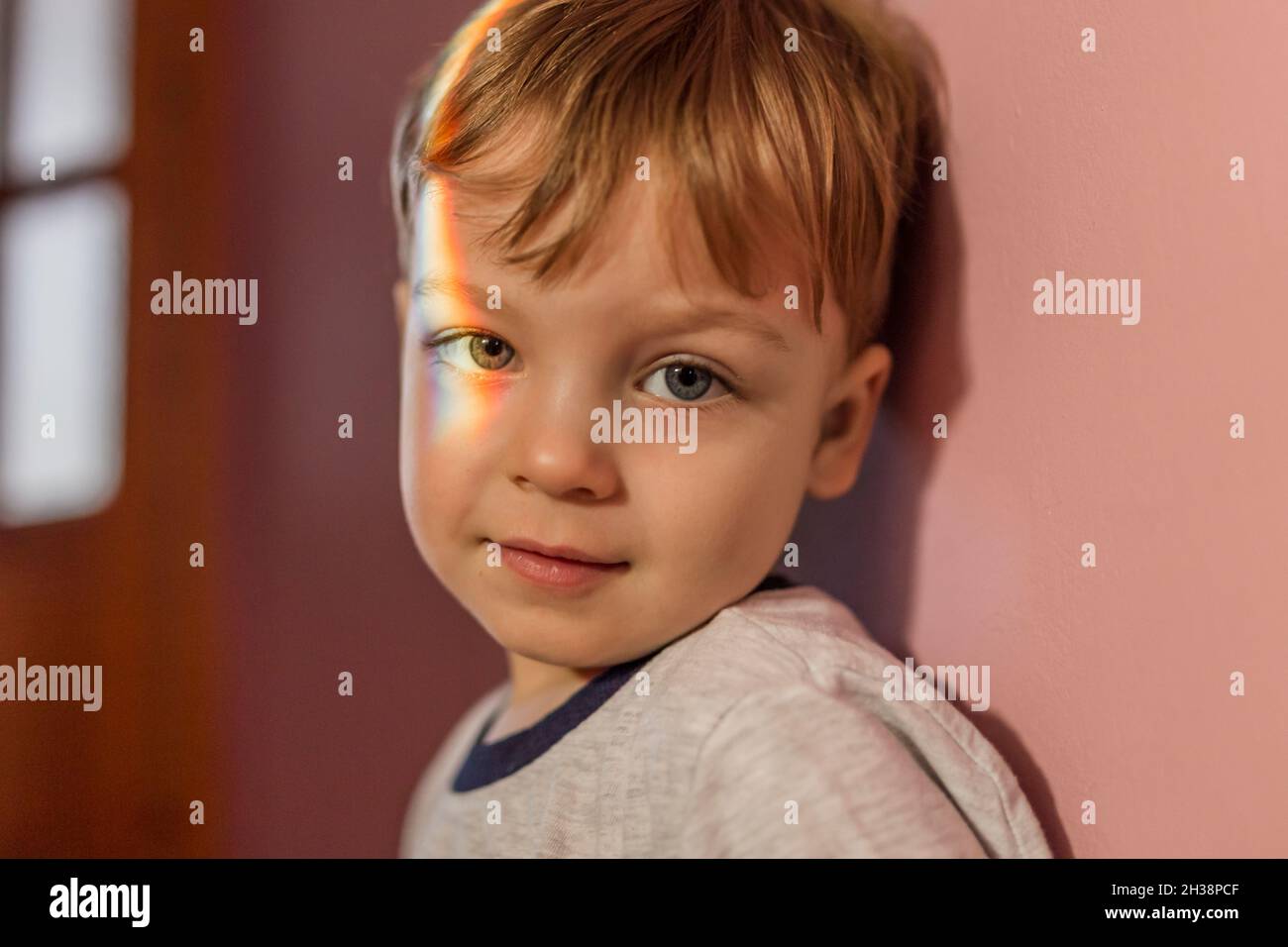 Ritratto di un bambino con la luce dell'arcobaleno sull'occhio destro Foto Stock