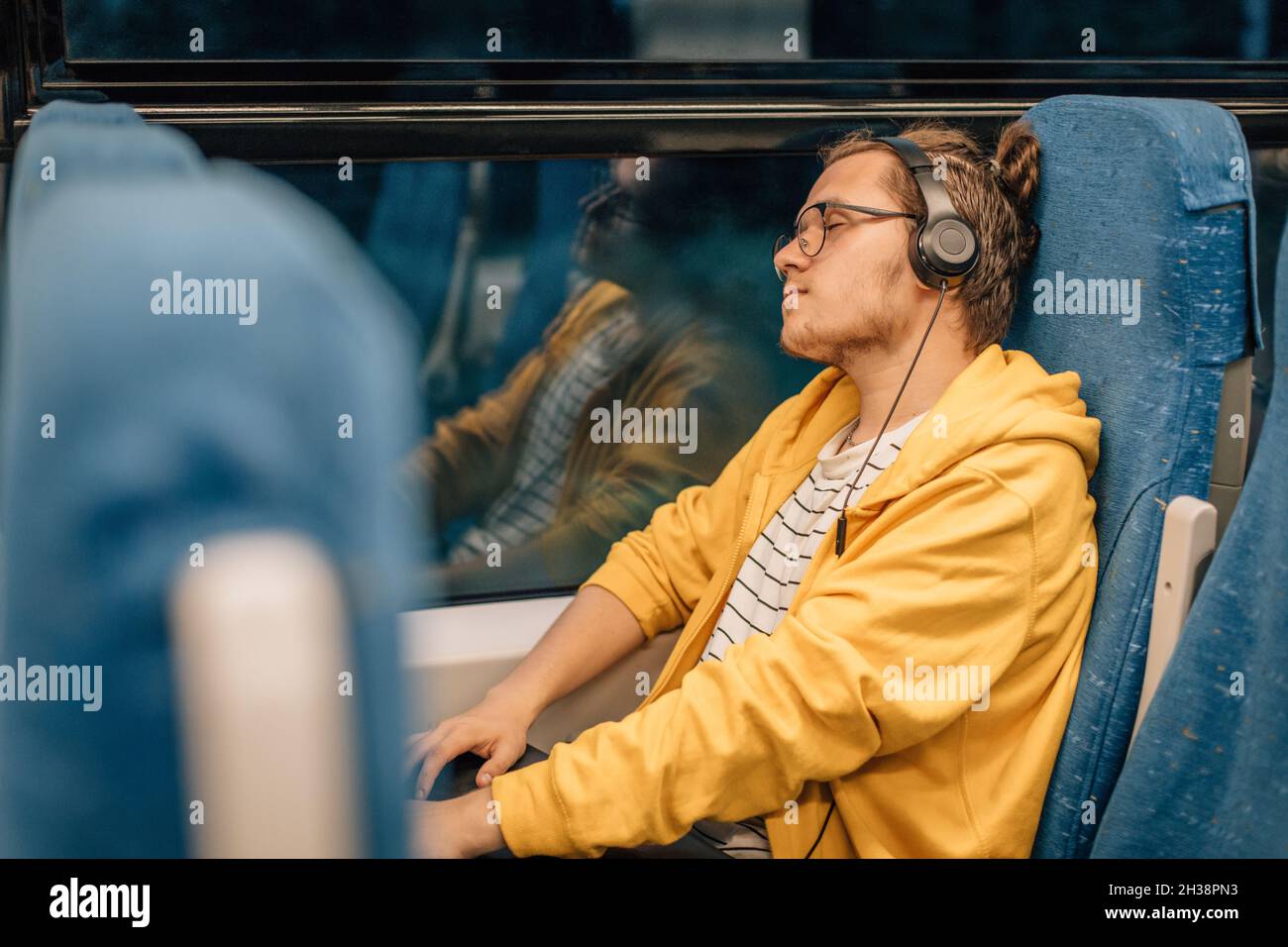 Giovane adolescente ascoltare musica, occhi chiusi, viaggi in treno. Foto Stock