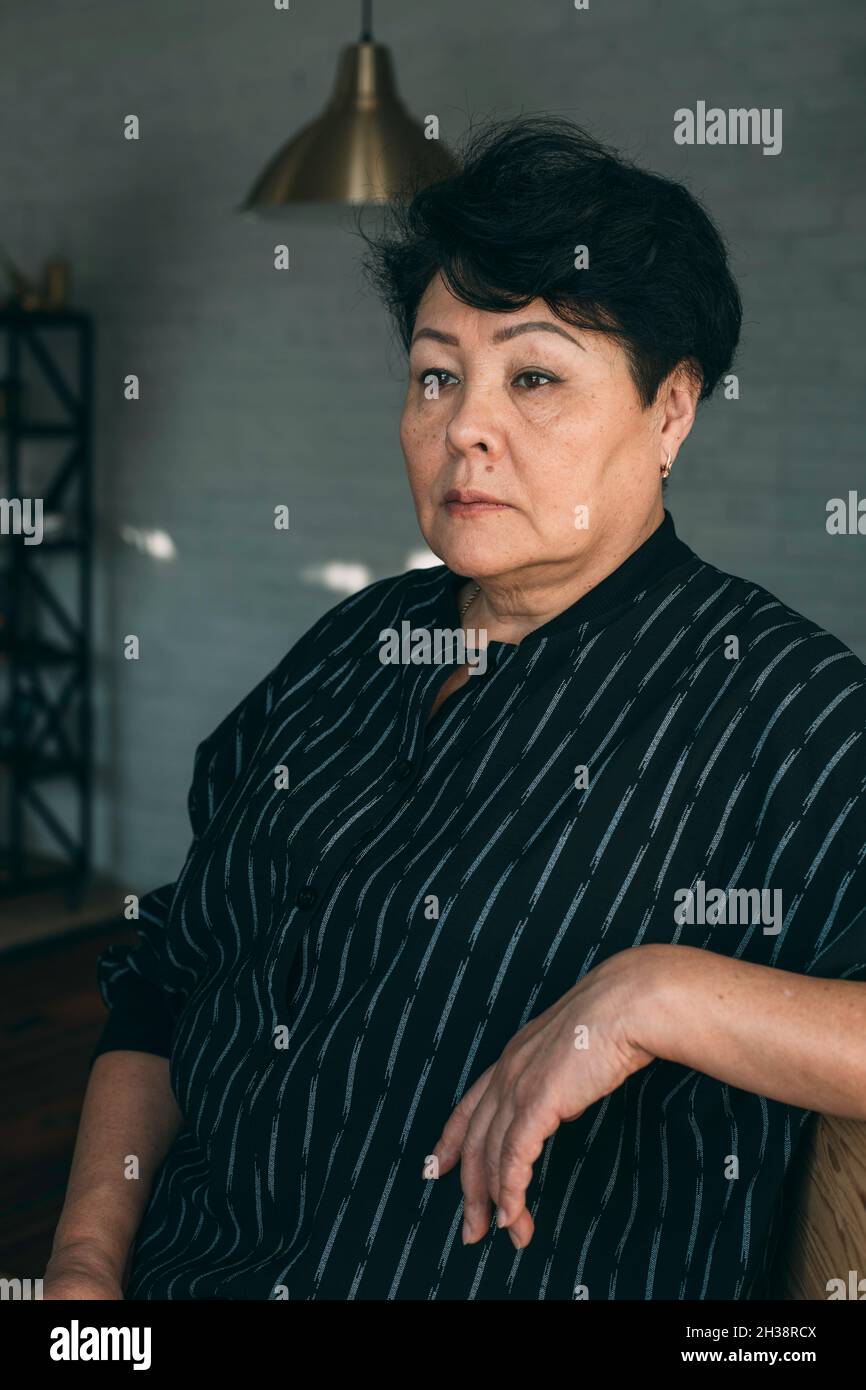 Ritratto di un attraente ed elegante donna senior in un momento di relax a casa. Foto Stock