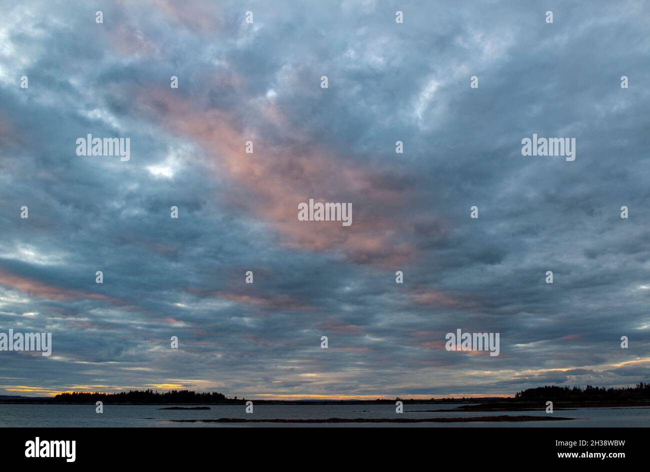Le nuvole si illuminano al tramonto sull'isola di Whaleboat. Baia di casco. Harpswell Neck, Maine. Foto Stock