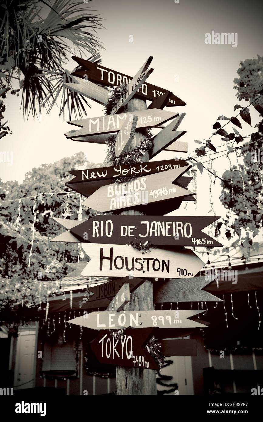Freccia direzionale segno a vari luoghi in tutto il mondo. Realizzato con frecce di legno sul cartello. Ogni nome di città ha le miglia da Key West, FL Foto Stock