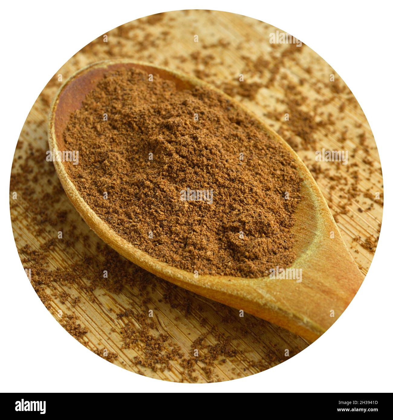 Spezie in polvere allspice in cucchiaio di legno, bambù su tagliere Foto Stock