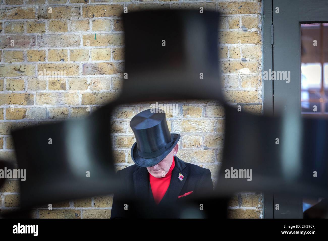 Un uomo in un cappello a Spitalfields, Londra orientale Foto Stock