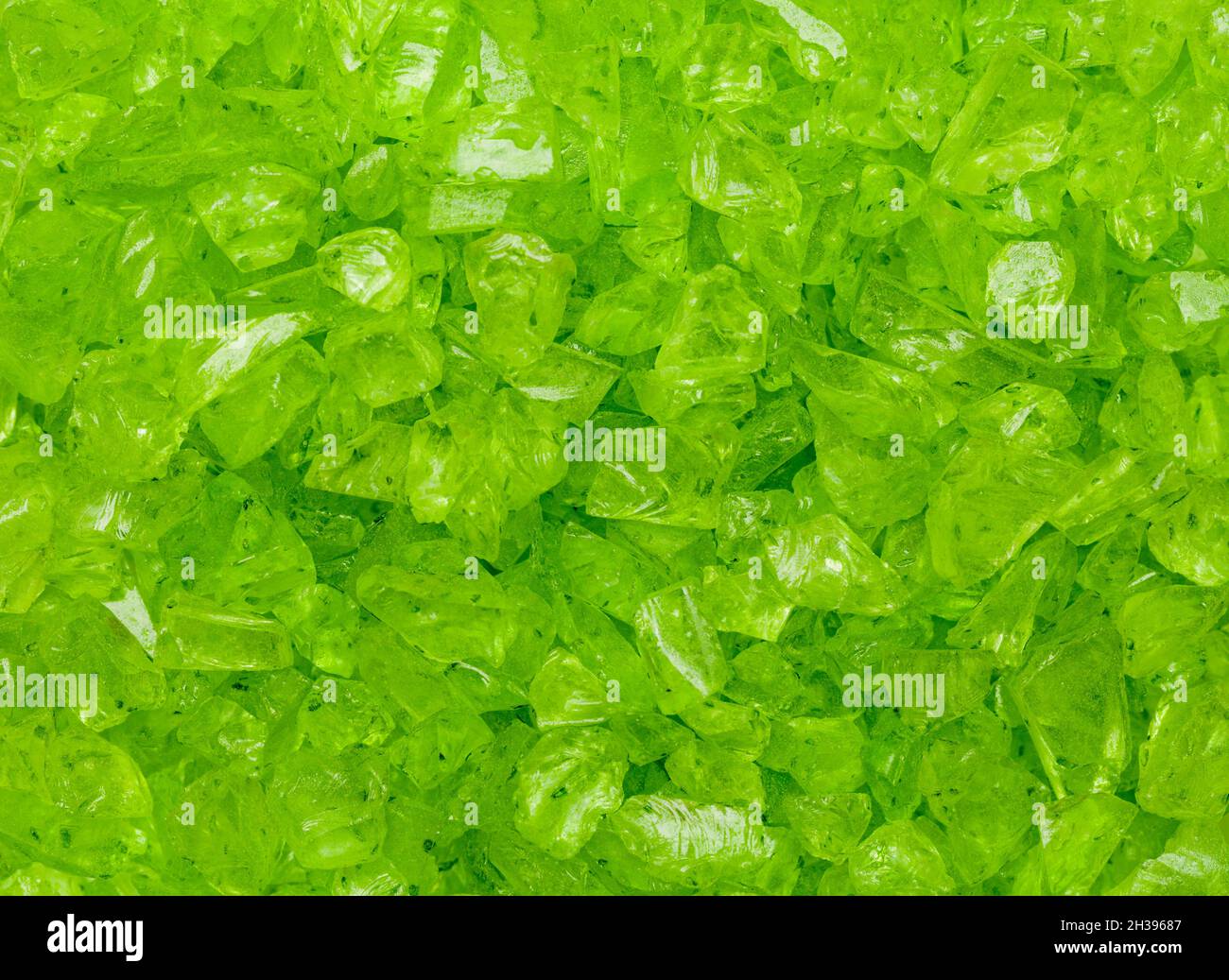 Pezzi di vetro verde rotto in uno sfondo pile. Foto Stock