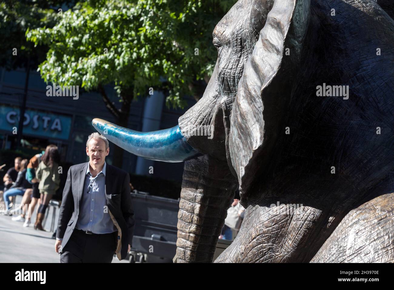 Un uomo si avvicina a una scultura di elefante, parte di mandria di speranza di Gillie e Marc, a Spitalfields, a est di Londra. Foto Stock