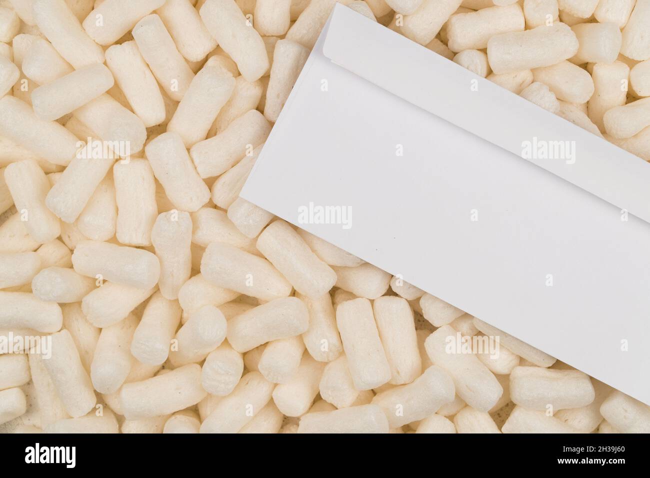 Fondo bianco di stucco e busta in polistirene espanso Foto Stock