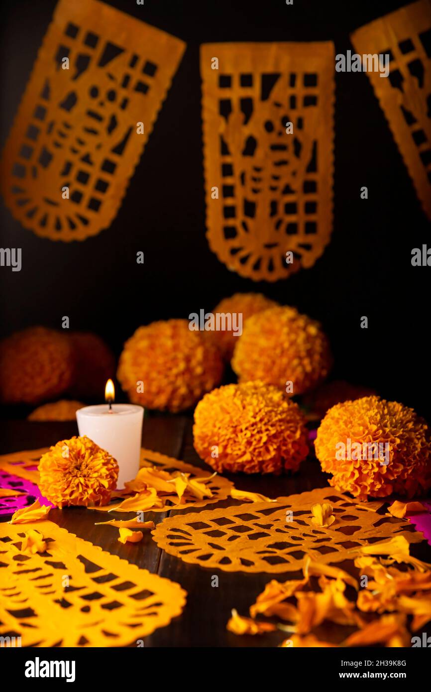 Candela con fiori d'arancio Cempasuchil o Marigold. (Tagetes erecta) e Papel Picado. Decorazione tradizionalmente utilizzata negli altari per la celebrazione di Foto Stock