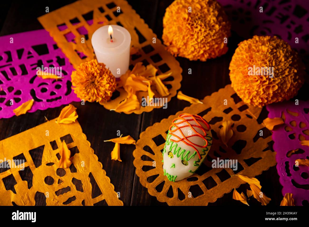 Cranio di zucchero con candela, fiori di Cempasuchil o Marigold e Papel Picado. Decorazione tradizionalmente utilizzata negli altari per la celebrazione del giorno della t. Foto Stock