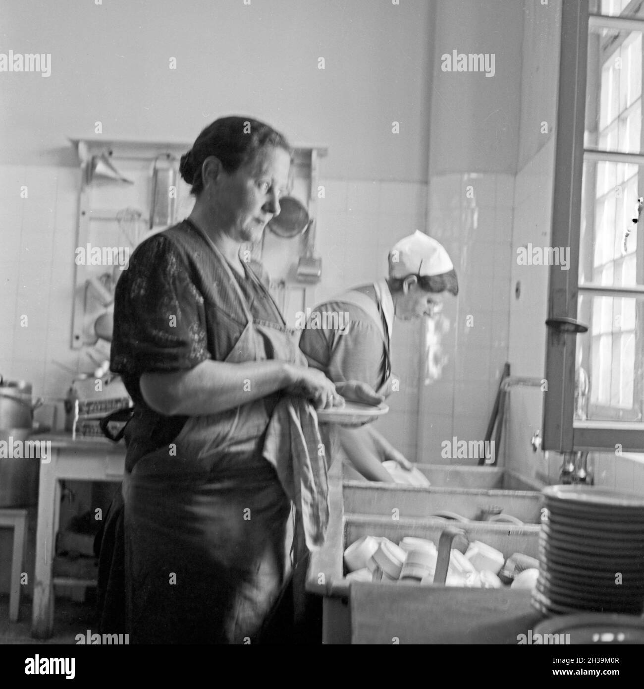 Frauen beim Spülen in der Küche des Mutter und tipo Heimes in Tabarz im Thüringer Wald. Le donne facendo il lavaggio fino nella cucina di una madre e un bambino ricreazione home a Tabarz, Turingia. Foto Stock