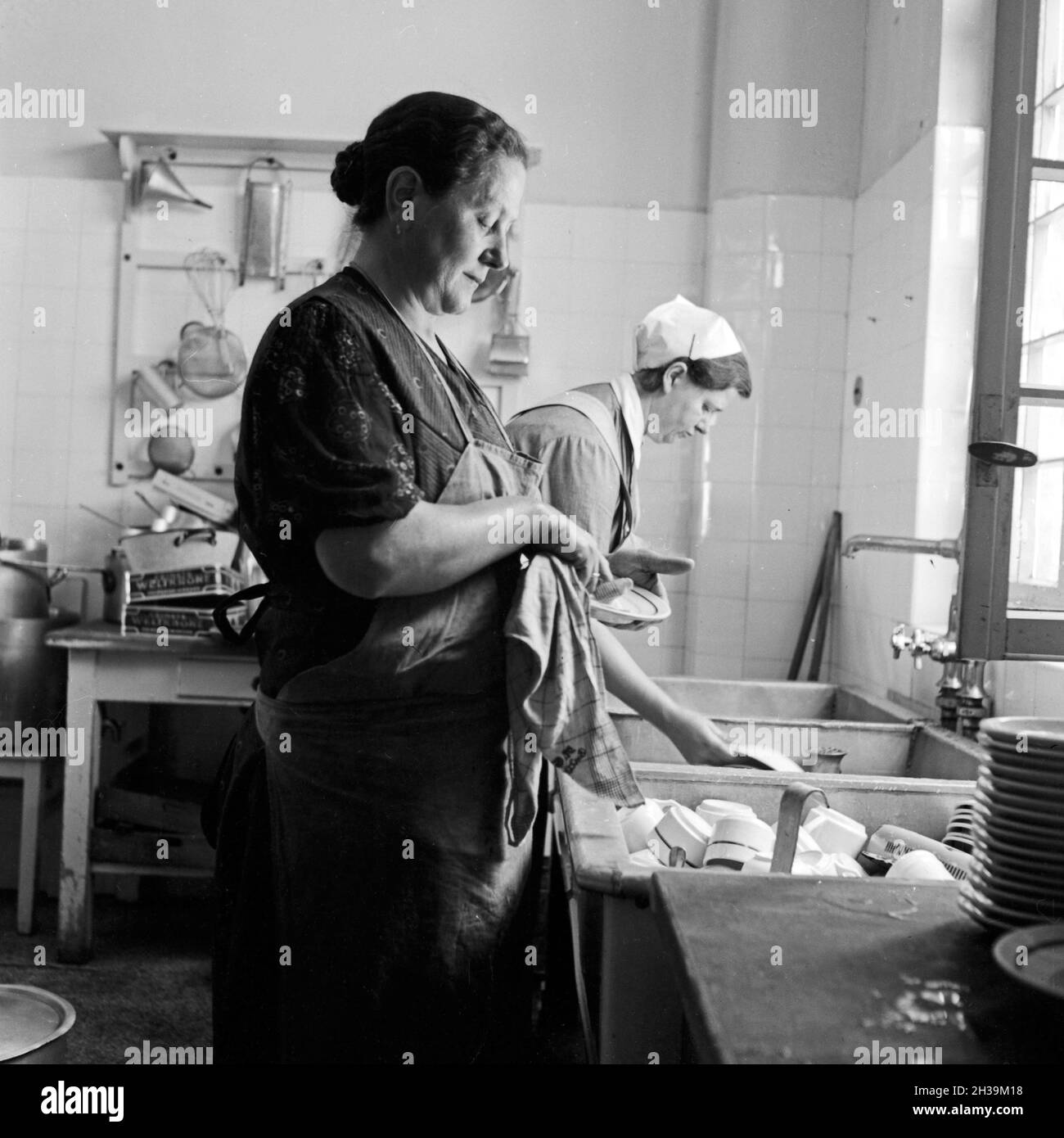 Frauen beim Spülen in der Küche des Mutter und tipo Heimes in Tabarz im Thüringer Wald. Le donne facendo il lavaggio fino nella cucina di una madre e un bambino ricreazione home a Tabarz, Turingia. Foto Stock