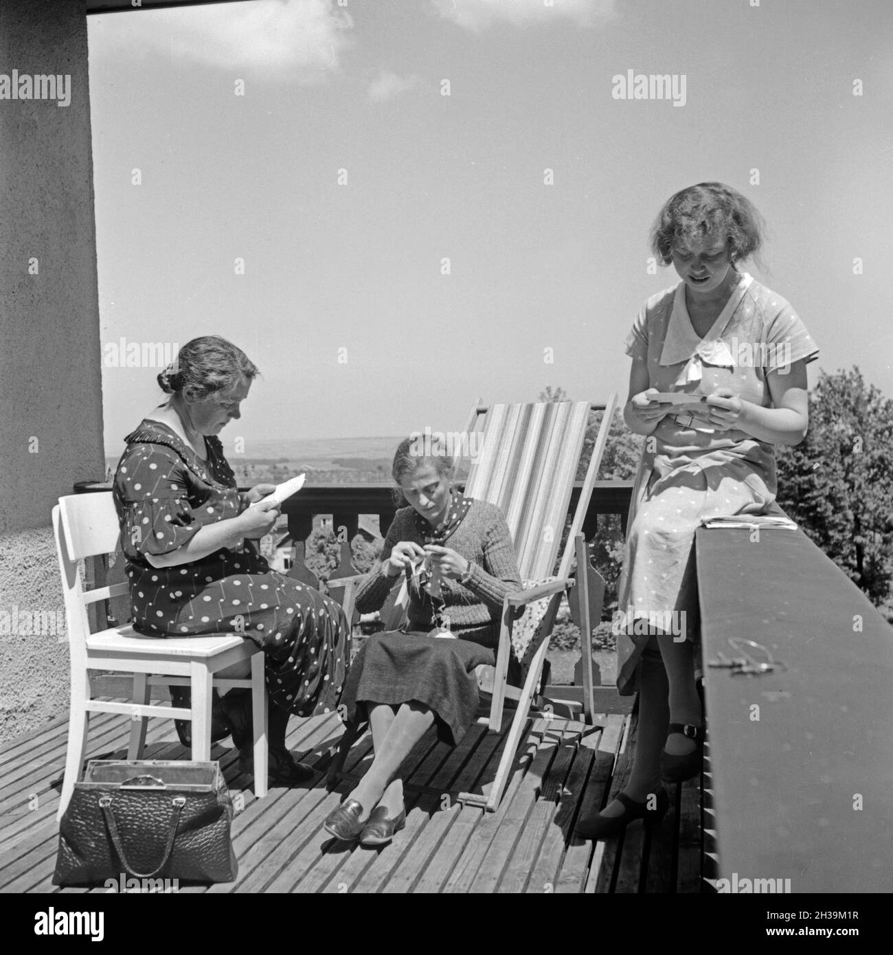 Drei Frauen entspannen sich bei Handarbeit und einer Unterhaltung im Mutter und tipo Heim in Tabarz, Thüringer Wald, 1930er Jahre. Tre donne rilassante mentre facendo qualche fancywork e una chat a un balcone di una madre e un bambino ricreazione home a Tabarz, Turingia. Foto Stock