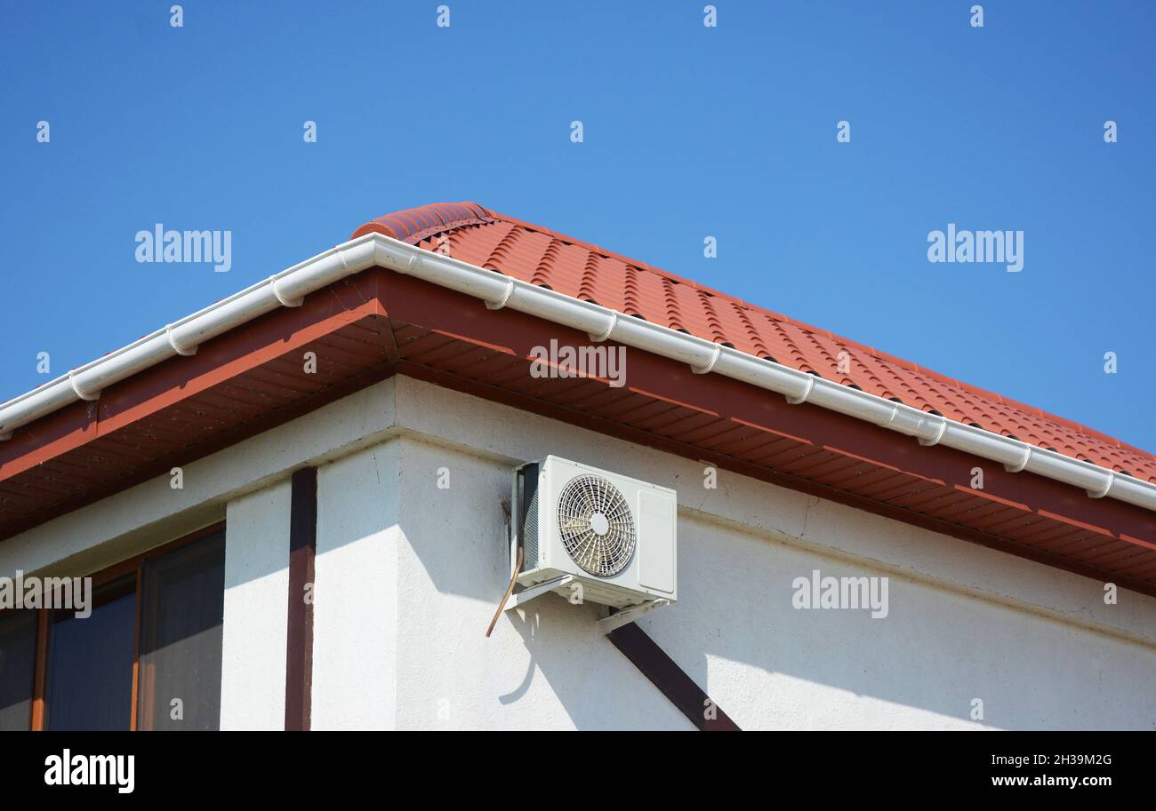Tetto di casa in argilla rossa con sistema di gruttering tetto in plastica, aria condizionata Foto Stock
