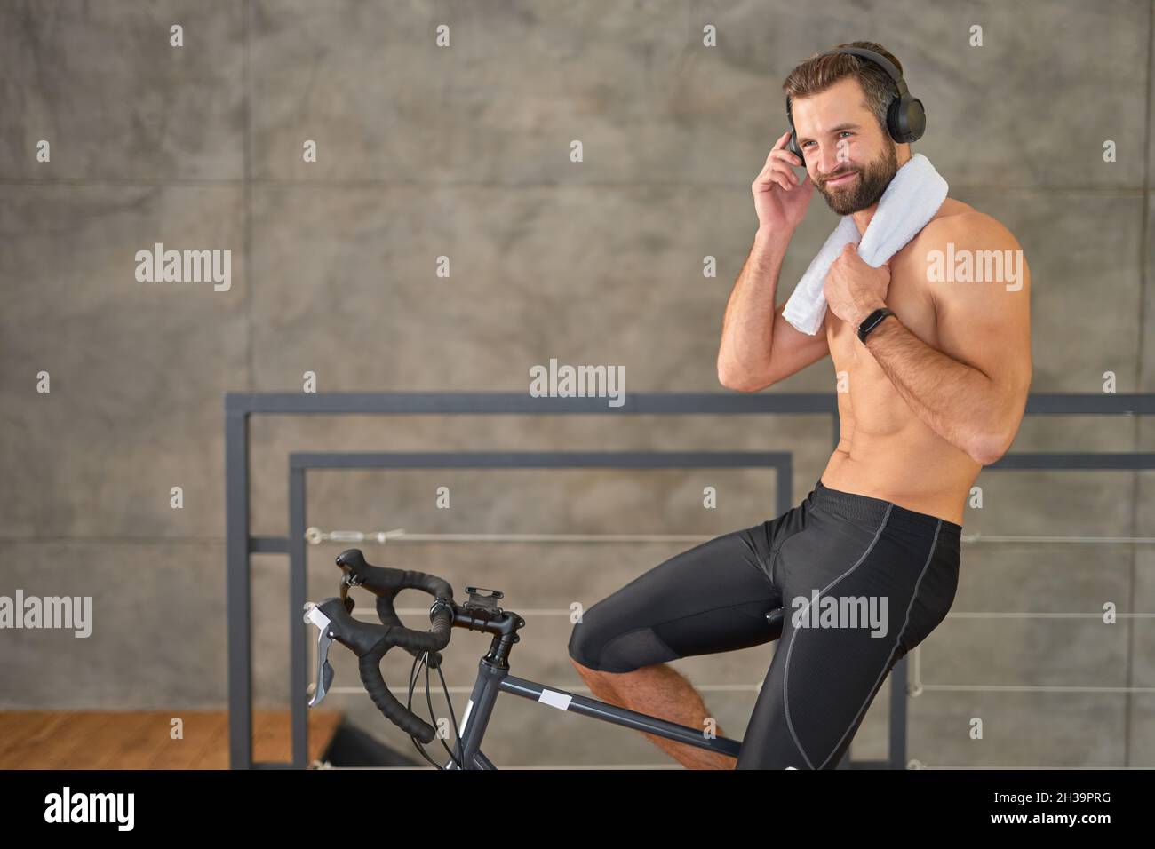L'uomo allegro che guida la bicicletta di esercitazione a casa Foto Stock