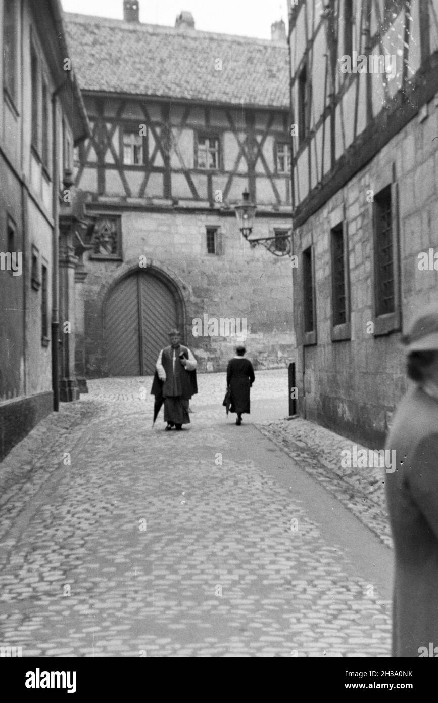 Pfarrer unterwegs in einer Stadt in Bayern, Deutschland 1930er Jahre. Sacerdote il suo modo attraverso una città della Baviera, Germania 1930s. Foto Stock