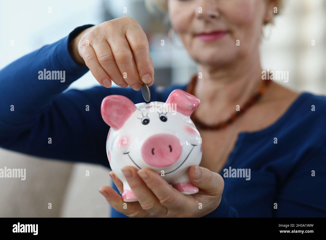 Senior Lady risparmiare reddito in contenitore Foto Stock