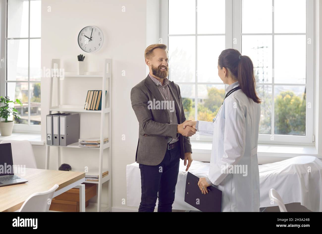 Stretta di mano del medico familiarizza con il paziente di sesso maschile Foto Stock