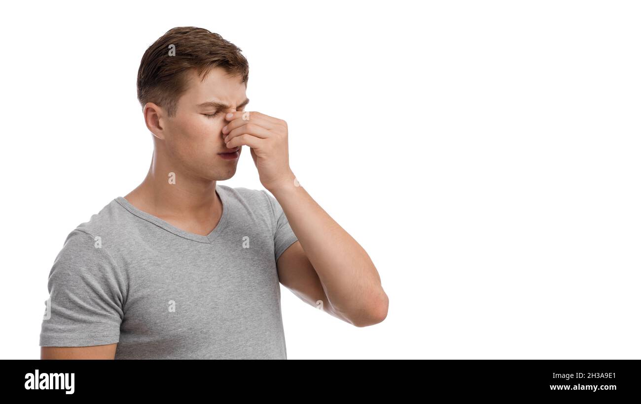 Triste uomo millenario europeo sconvolto da naso che cola o mal di testa, volto toccante Foto Stock