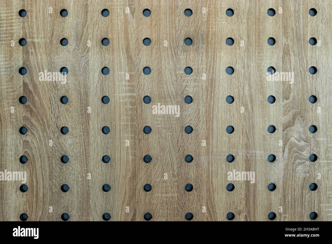 Sfondo in legno a trama astratta con fori. Foto Stock