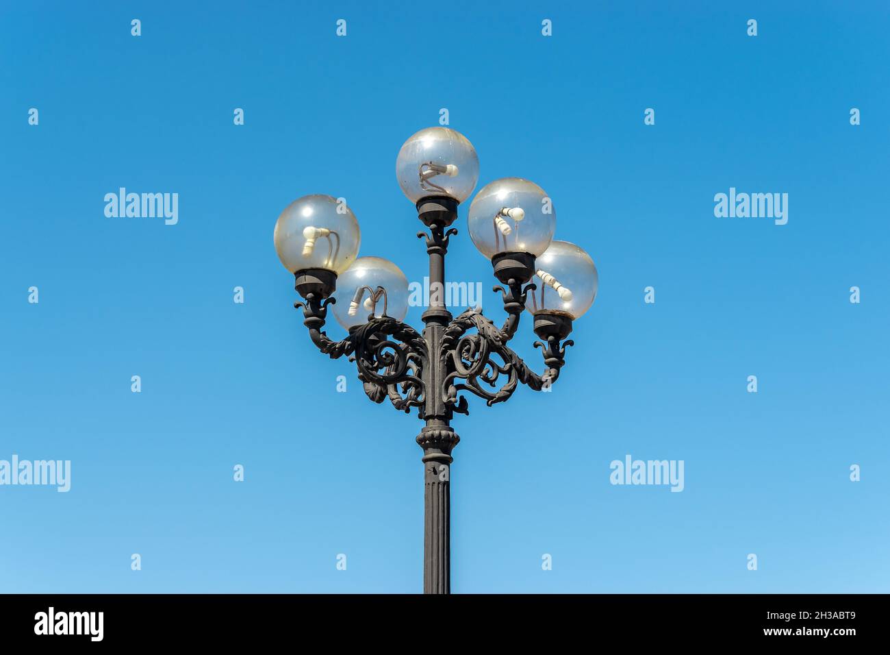 Vecchio lampione su strada con sfondo cielo blu. Foto Stock
