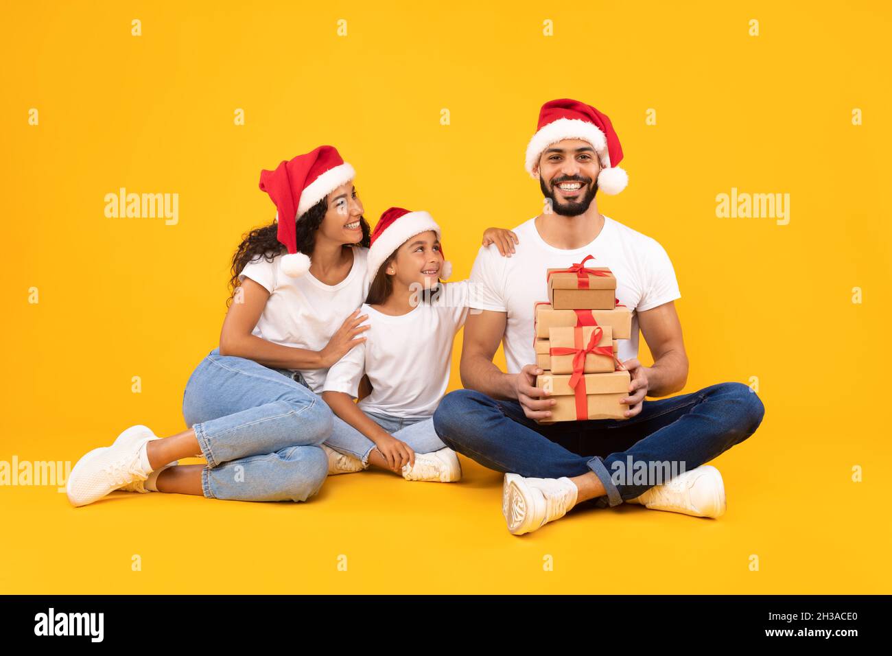 Famiglia araba gioiosa in posa con regali di Natale, Studio Shot Foto Stock