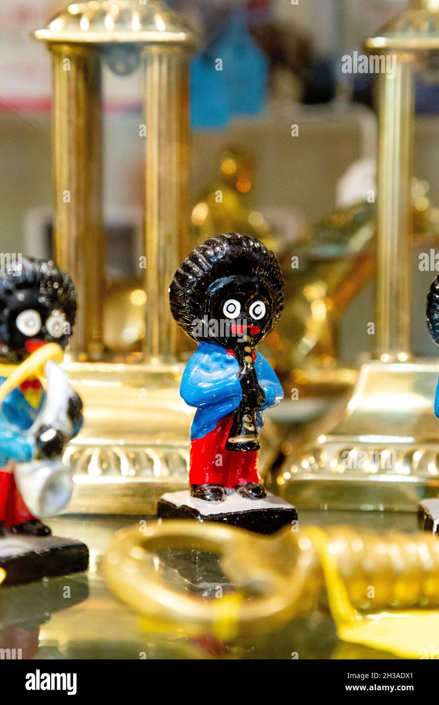 Golliwog figurine di un musicista nero che suona una tromba in mostra presso un negozio di antiquariato (Hampton Court Emporium, East Molesey, Regno Unito) Foto Stock