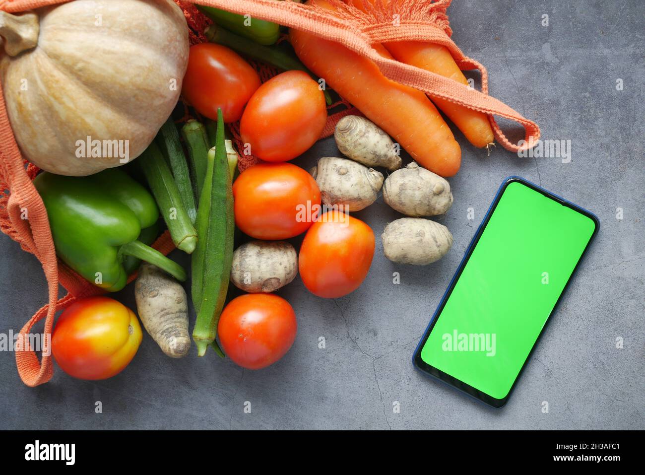 vista dall'alto dello smartphone con verdure fresche sul tavolo Foto Stock