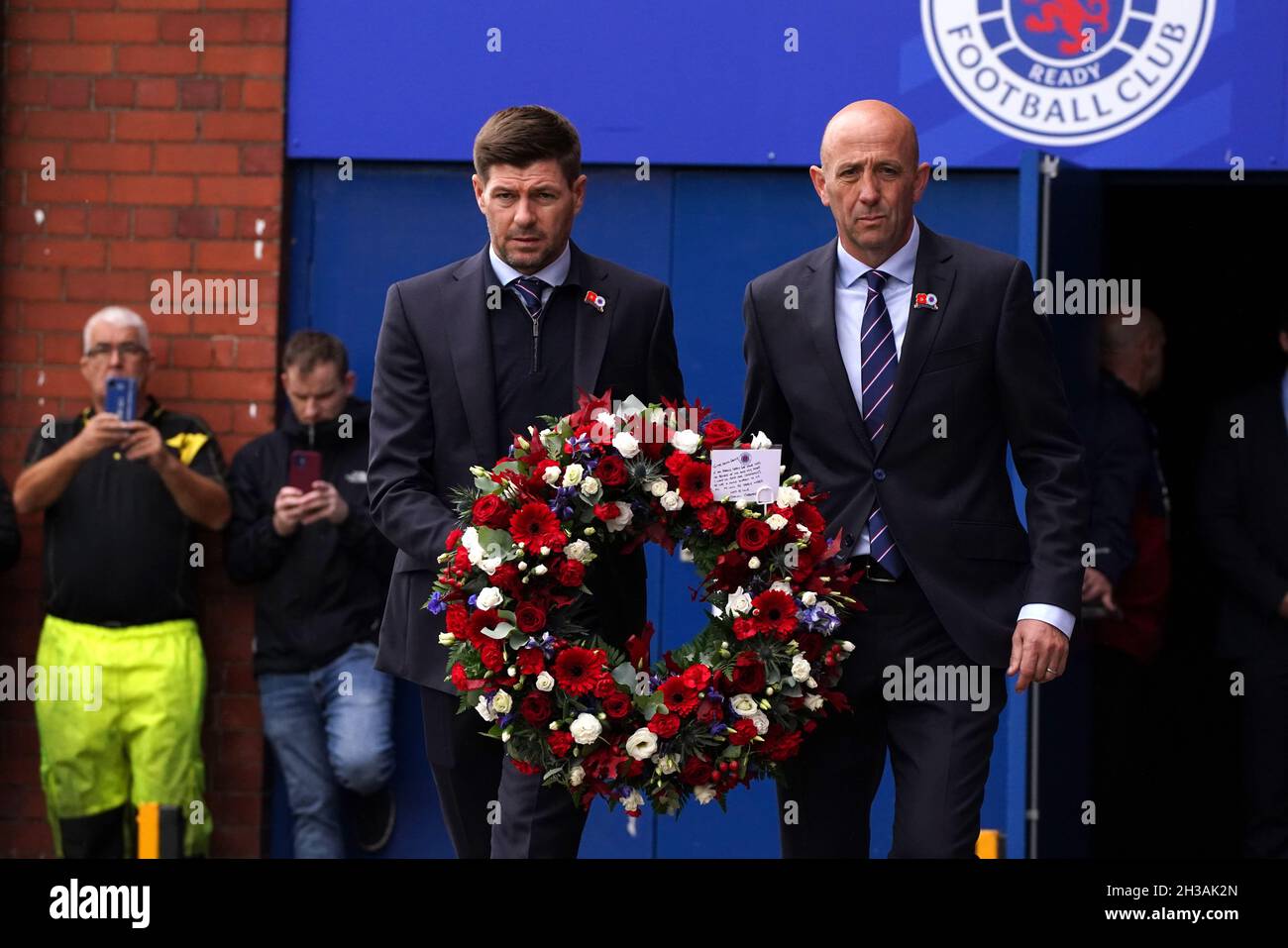 Il manager dei Rangers Steven Gerrard accanto all'allenatore Gary McAllister (a destra) porta una corona da posare all'Ibrox Stadium in memoria dell'ex Scozia, Rangers e Everton manager Walter Smith morto ieri (martedì 26 ottobre) di 73 anni. Data foto: Mercoledì 27 ottobre 2021. Foto Stock