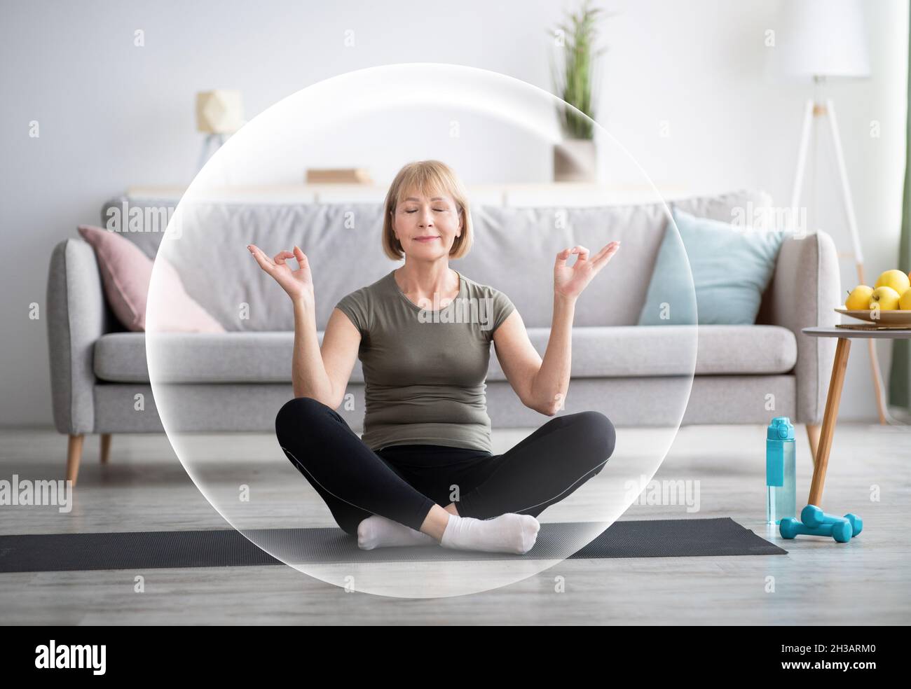 Serena calma contented felice matura donna europea meditating in soggiorno interno in bolla protettiva Foto Stock