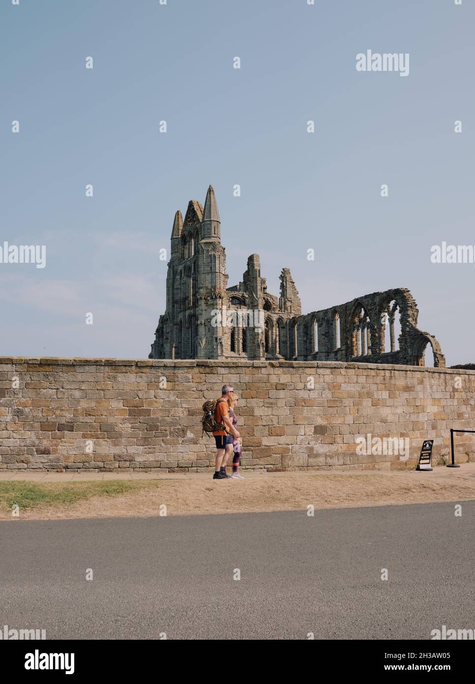 Turisti e ingresso alle rovine gotiche dell'Abbazia di Whitby un monastero cristiano del 7° secolo divenne in seguito un'abbazia benedettina gestita dal patrimonio inglese Foto Stock