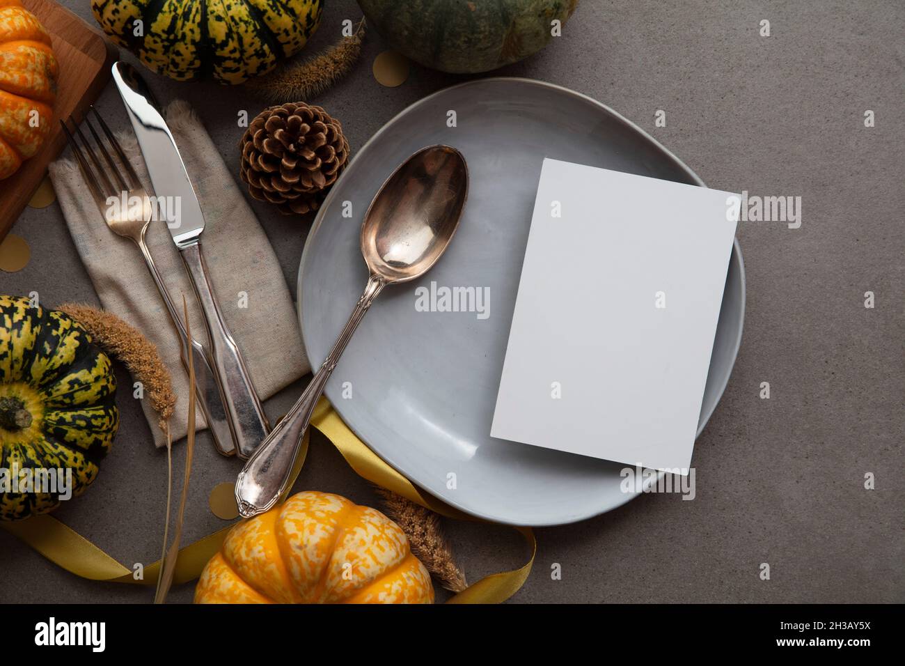 Tabella di ringraziamento autunno impostazione con menu vuoto invita scheda circondato da zucche festive Foto Stock