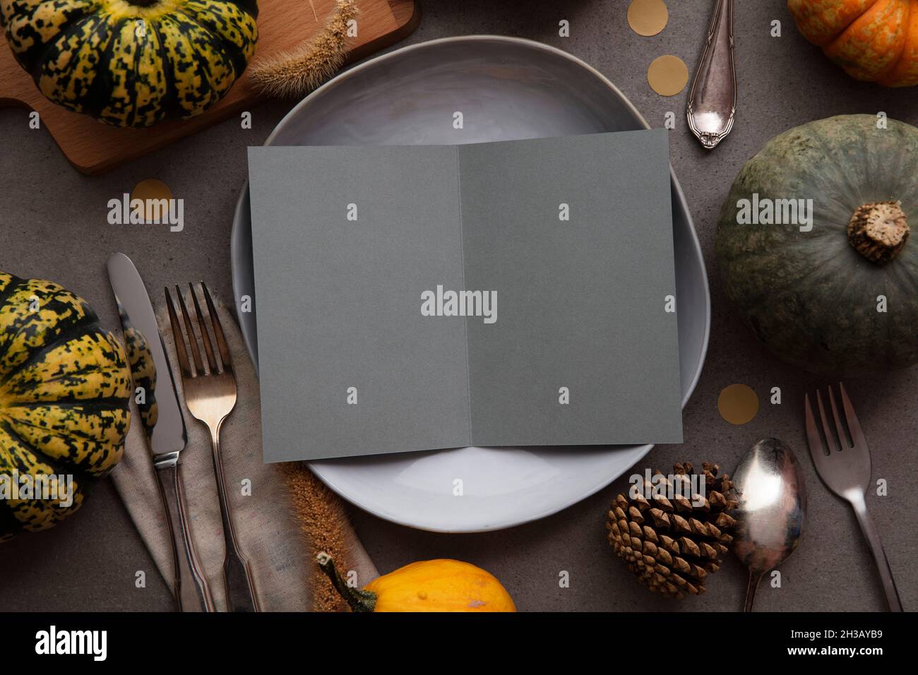 Tabella di ringraziamento autunno impostazione con menu vuoto invita scheda circondato da zucche festive Foto Stock