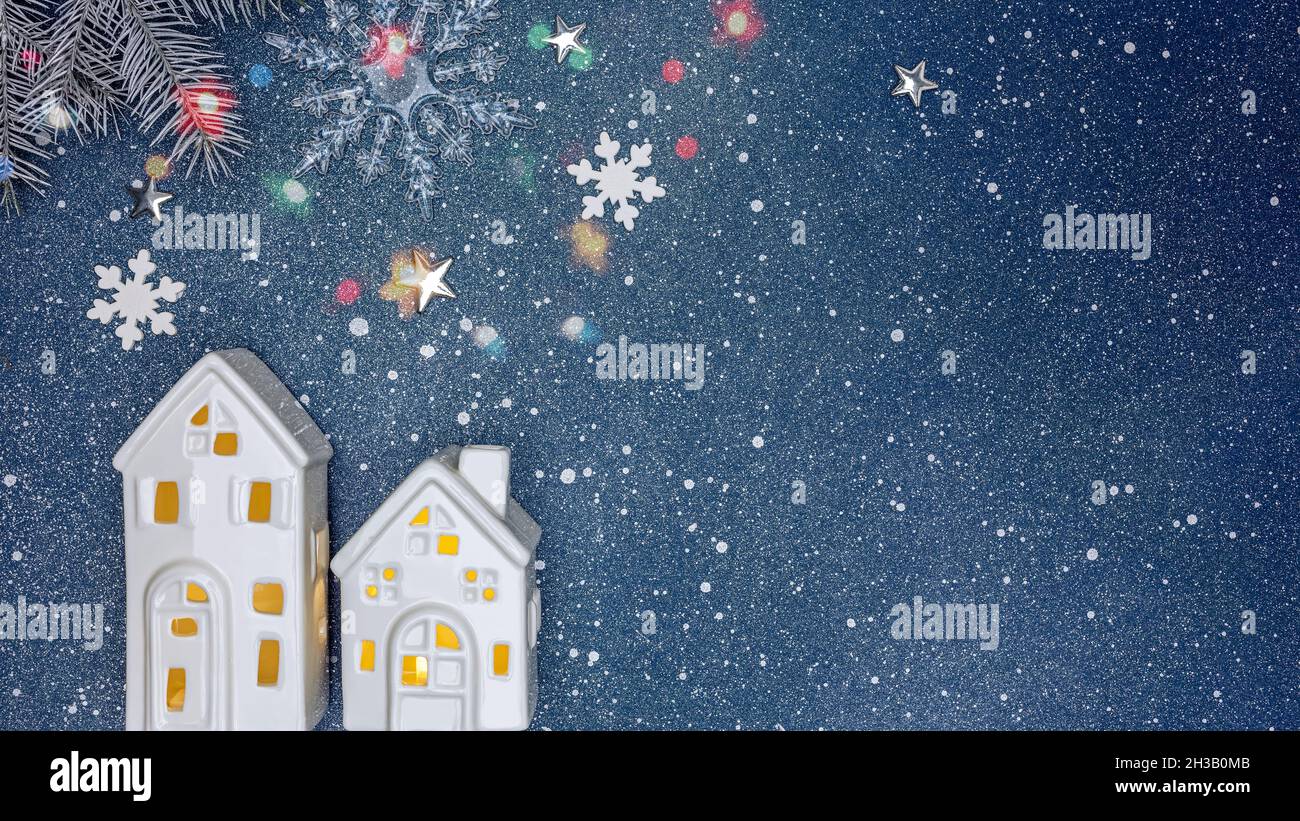 sfondo natalizio con piccole case bianche giocattolo e ramo di abete Foto Stock