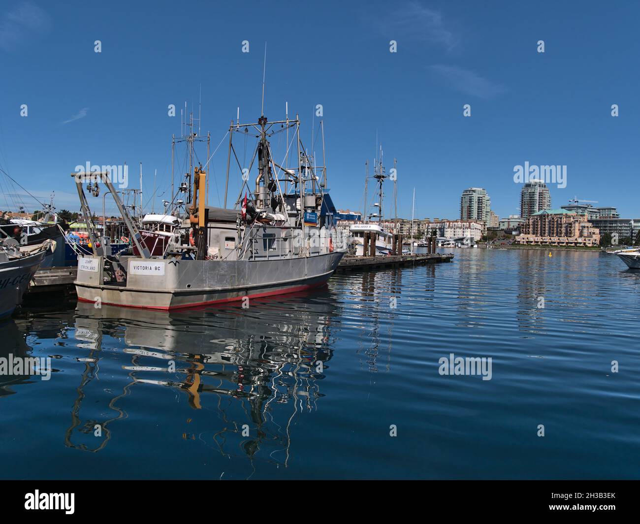 Vista di Victoria Harbour con nave RV John Strickland, utilizzato per la ricerca marina da parte dell'Università di Victoria, con skyline sullo sfondo. Foto Stock