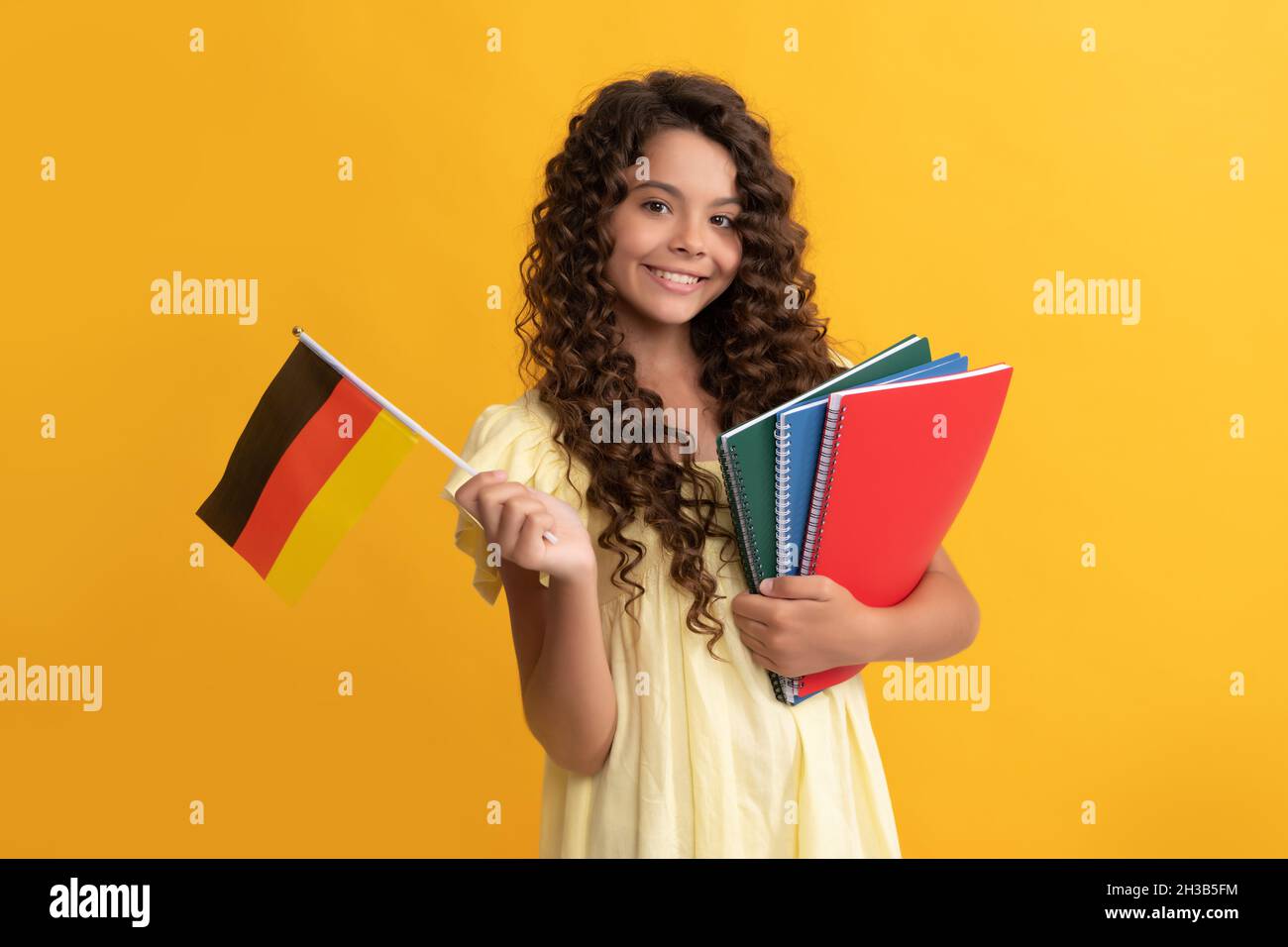 lingua tedesca. bandiera di tenuta del bambino. torna a scuola. studia teen girl in germania. infanzia felice. Foto Stock