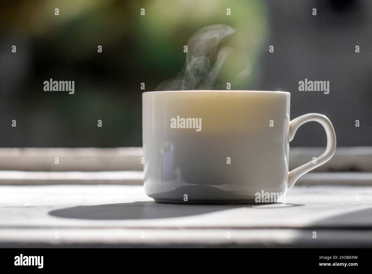 Un bicchiere di caffè caldo su un vecchio davanzale Foto Stock