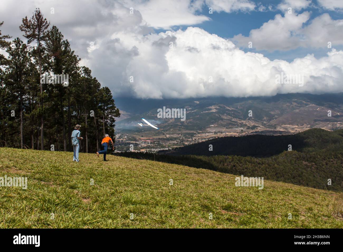 le persone che hanno divertente aeroplani volanti su una montagna all'aperto Foto Stock