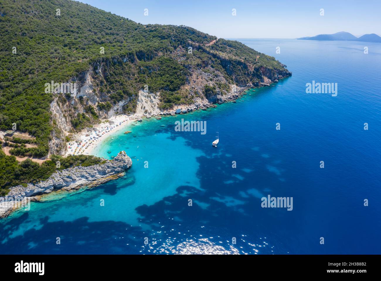 Foto aerea del drone del paradiso iconico spiaggia sabbiosa di Agiofili vicino al porto di Vasiliki con mare cristallino smeraldo e barche a vela ancorate, Lefkada Foto Stock