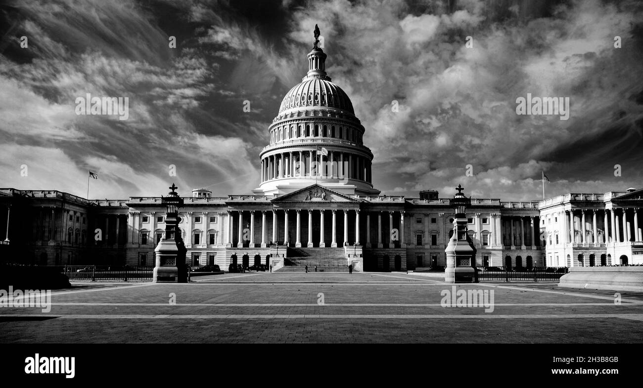 United state Capitol Building per congressi con bandiera americana che scorre nella brezza e colonne cielo blu e nuvole sullo sfondo Foto Stock