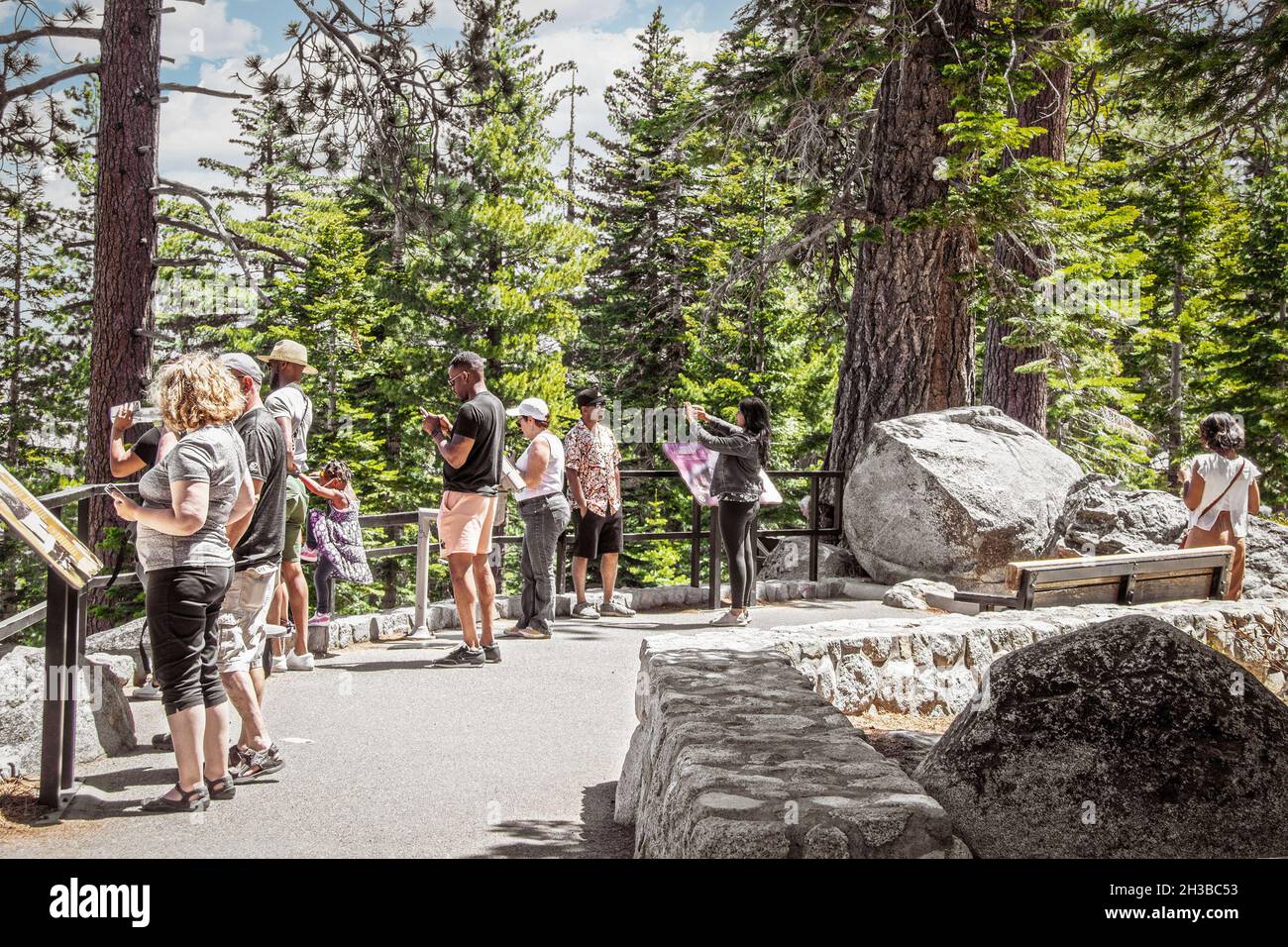 2021 06 01 Lake Tahoe - i turisti a guardare fuori mappa e prendere selfie sul lago con alberi sempreverdi sullo sfondo. Foto Stock