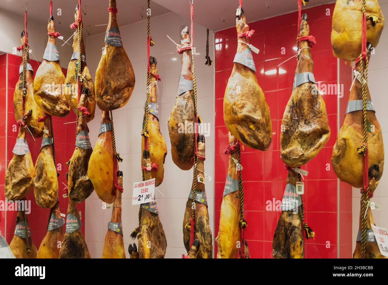 Grandi carcasse di jamon spagnolo appendono in una vetrina Foto Stock