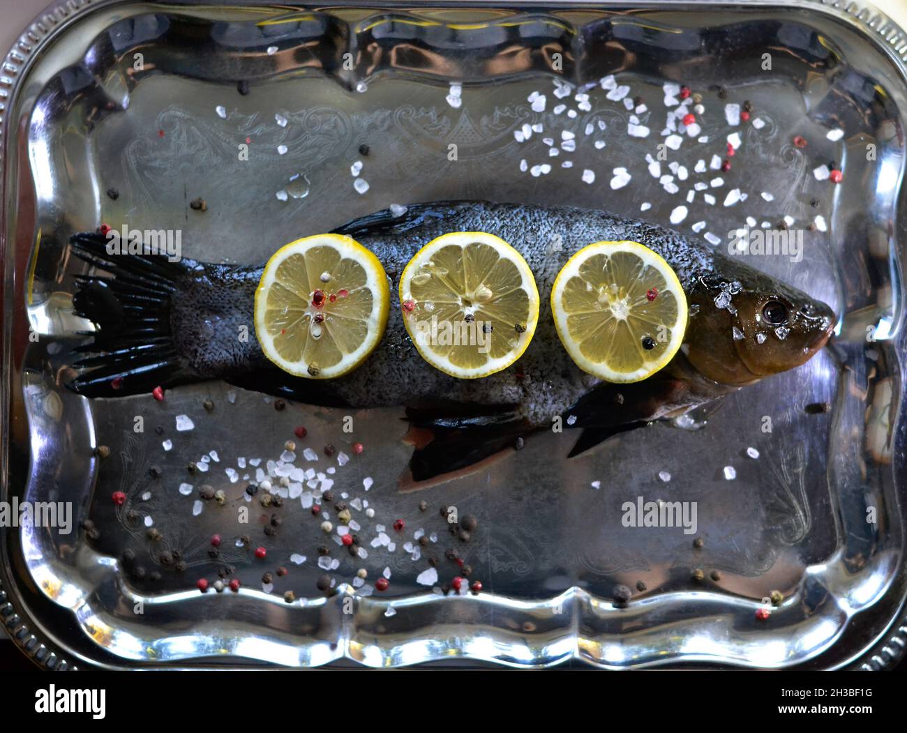 Pesce fresco con limoni, peperoni e sale Foto Stock