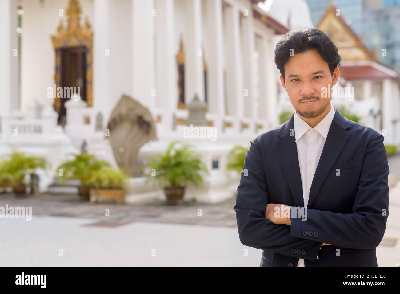 Uomo d'affari asiatico rilassarsi all'aperto in città al tempio buddista Foto Stock