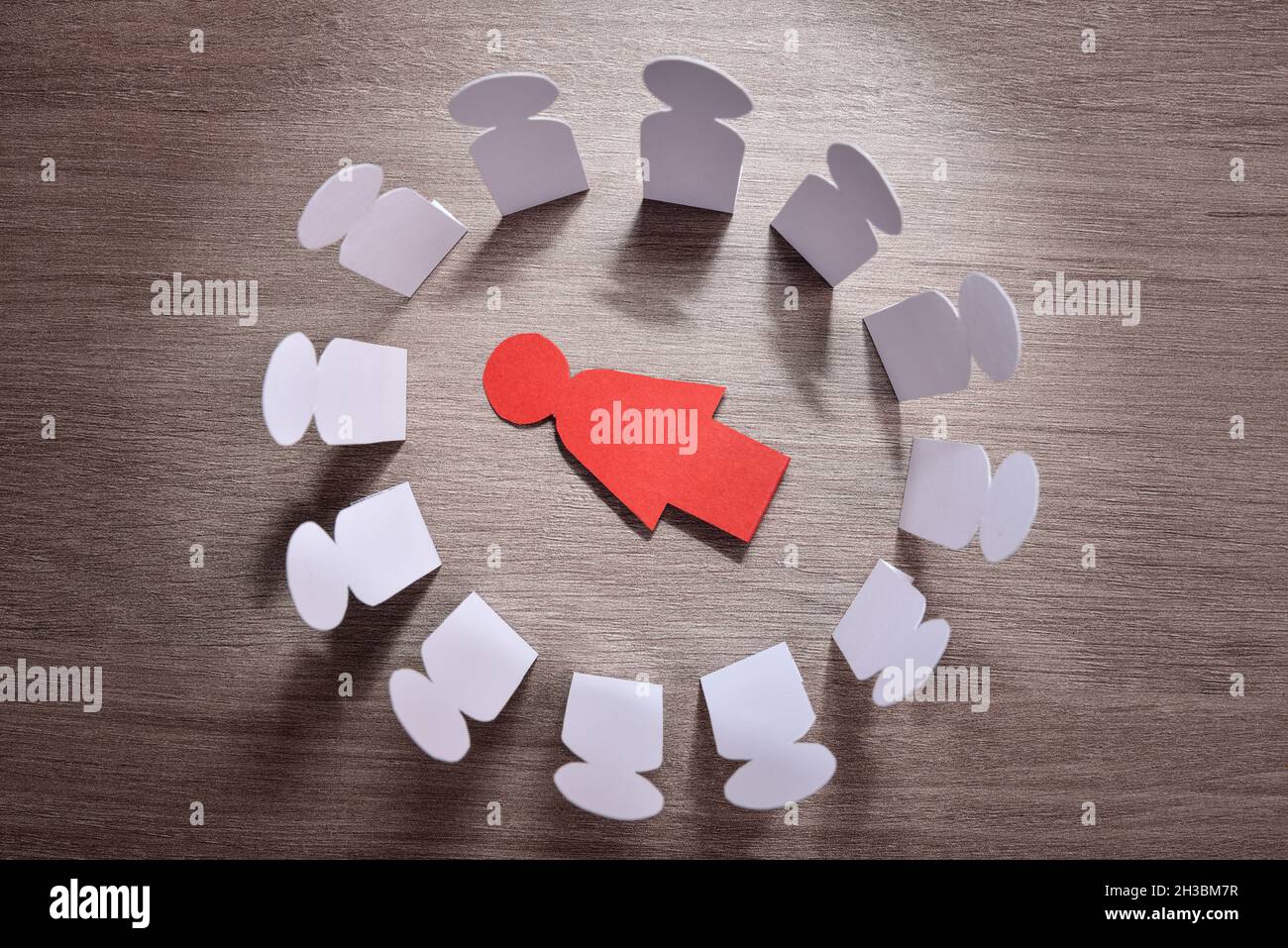 Concetto di morte di una donna a causa della violenza di genere e della pressione sociale con esclusione di una donna che giace sul tavolo e gruppo di uomini in piedi intorno. Foto Stock