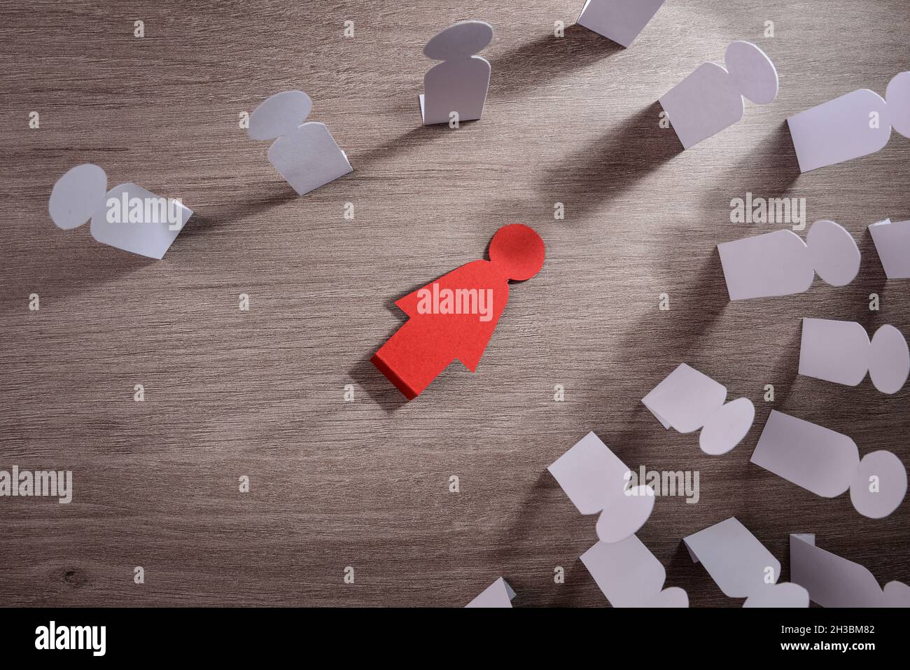 Concetto di morte di una donna a causa della violenza di genere e della pressione sociale con esclusione di una donna che giace sul tavolo e la gente intorno. Foto Stock