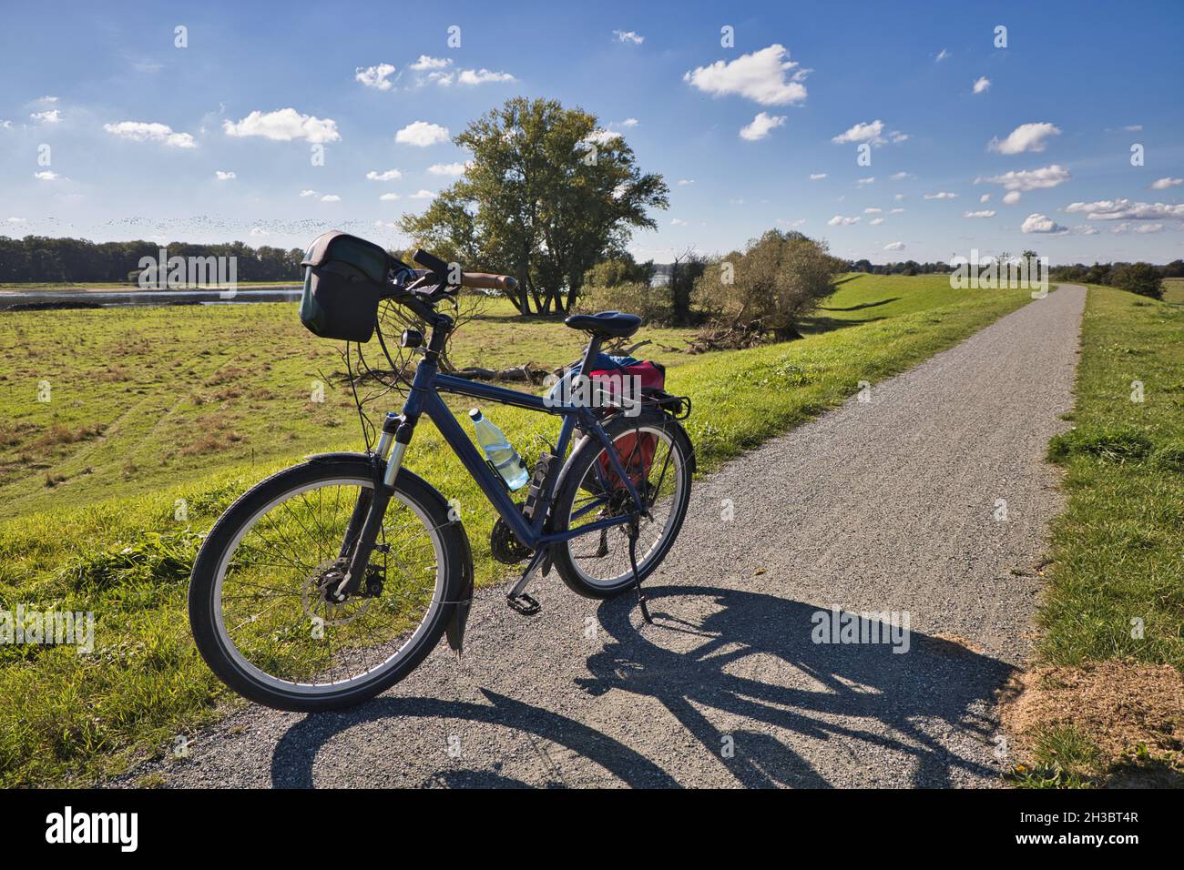 bicicletta sulla diga sulla pista ciclabile dell'elba sullo sfondo del fiume tedesco elbe, è il sentiero della cortina di ferro Foto Stock