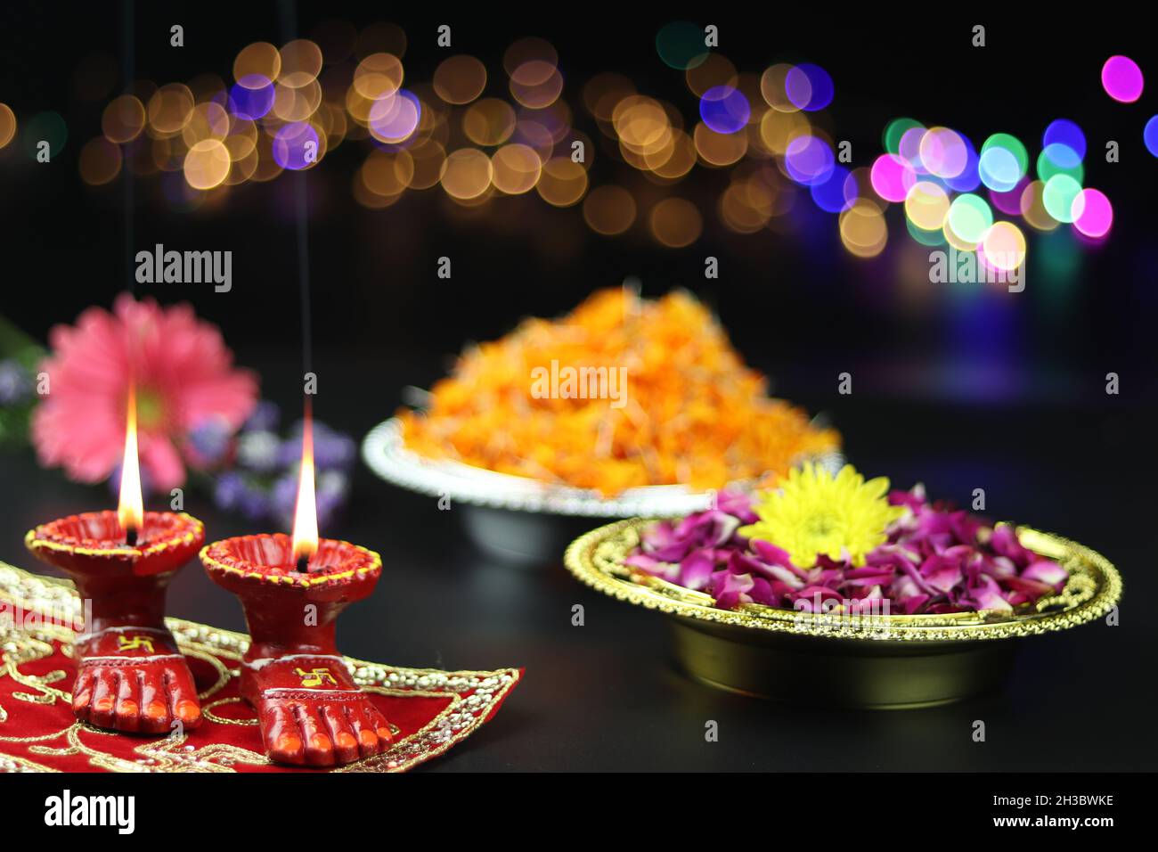 Clay Lamp conosciuta come Diya, Deep, Diyo, Deepa o Deepam con i piedi della dea Lakshmi Charan illuminando con i fiori e l'effetto Bokeh. Shubh Deepawali e. Foto Stock