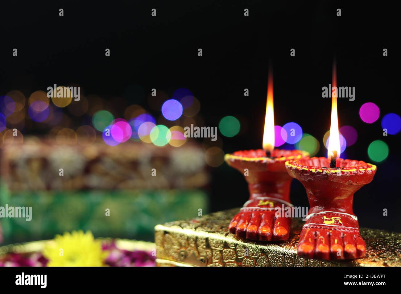 Clay Lamp conosciuta come Diya, Deep, Diyo, Deepa o Deepam con i piedi della dea Lakshmi Charan illuminando su Golden Gift Box con effetto Bokeh. Shubh Deepawa Foto Stock