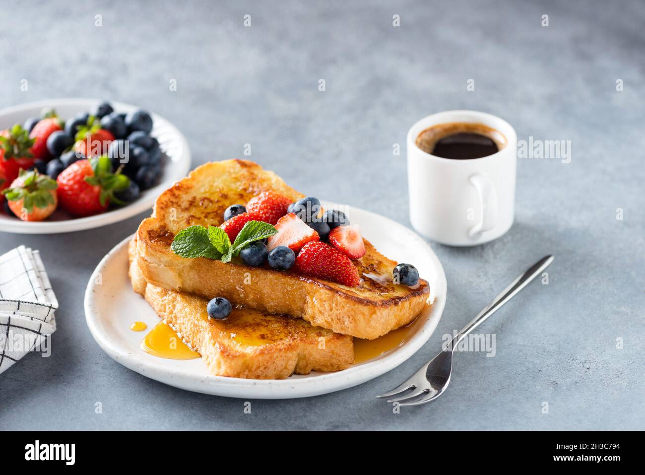 Toast alla francese con frutti di bosco e sciroppo servito sul piatto. Spazio di copia per il testo o gli elementi di disegno Foto Stock